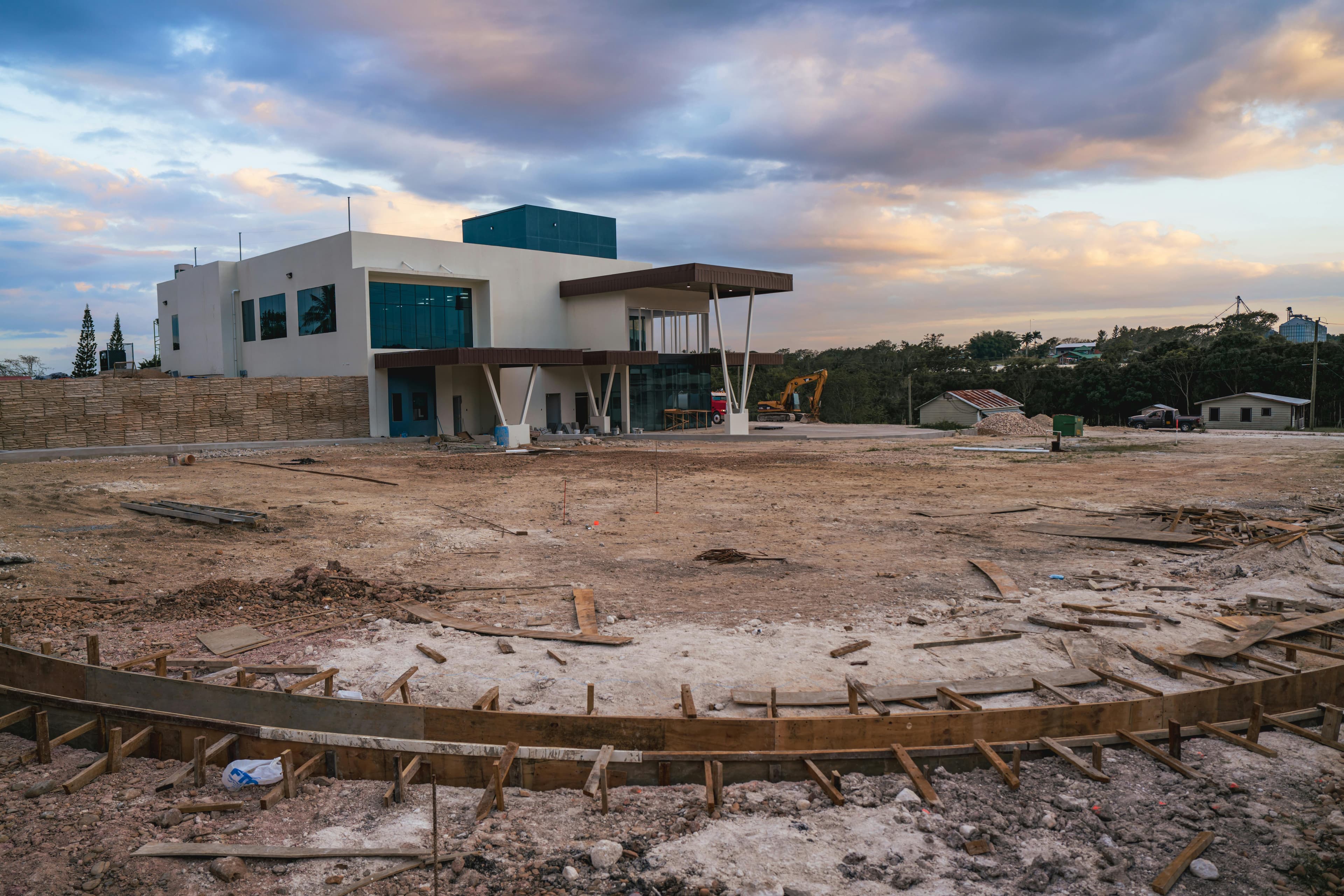 An active construction site featuring a modern commercial building under development at dusk, representing a high-growth real estate investment opportunity and future infrastructure potential.